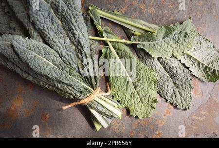 Fresh black cabbage leaves on stone background. Black kale. Italian food. Healthy eating cooking step, ready to prepare vegetarian food Stock Photo