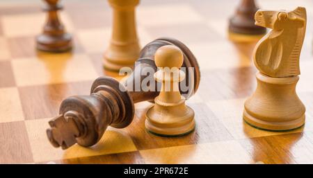 Chess pieces on a chessboard - Checkmate Stock Photo