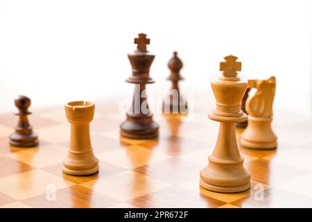 Chess pieces on a chessboard with white background Stock Photo