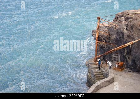 Couple of sport fishermen on an old pier. Stock Photo