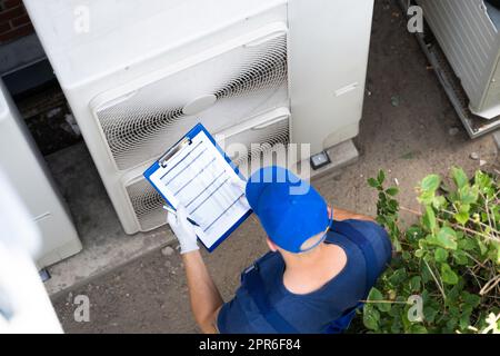 An Electrician Men Checking Air Conditioning Unit Stock Photo