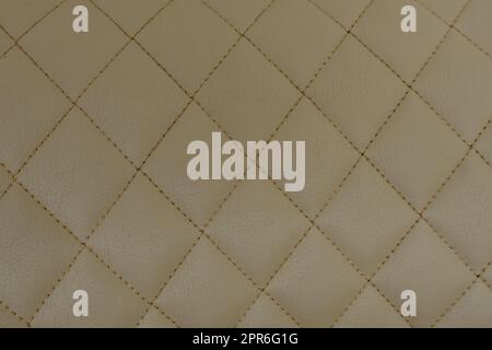 Background of beige leather quilted in the form of rhombuses Stock Photo