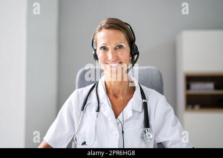 Confident Receptionist Using Headset In Hospital Stock Photo