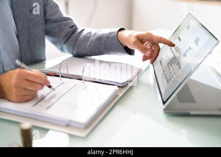 Businessman's Hands Working On Invoice On Laptop Stock Photo