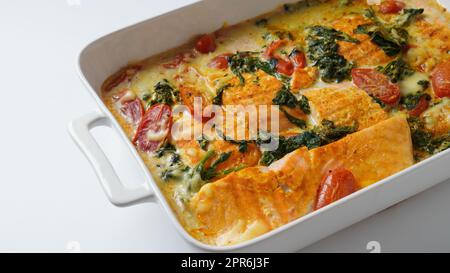 Salmon Fillet  with spinach and cherry tomatoes in creamy sauce Stock Photo