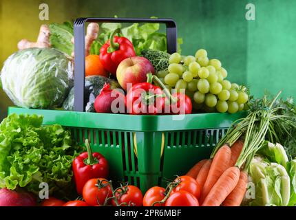 Fresh organic fruits and vegetables in plastic shopping basket Stock Photo