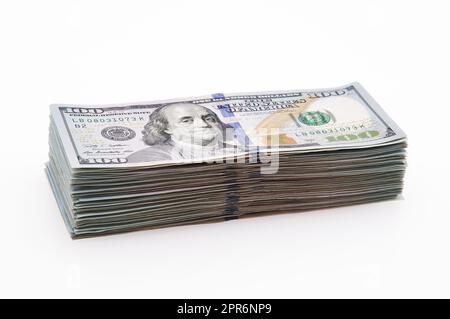 A large stack of hundred-dollar cash bills on a white background. Isolated. Stock Photo