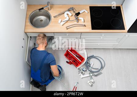 Plumber Cleaning Clogged Sink Pipe Stock Photo