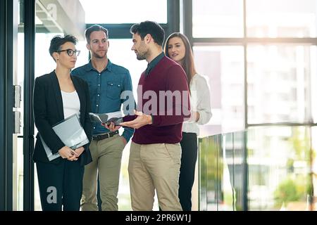 Another successful meeting in the books. Shot of a group of colleagues talking together in a large modern office. Stock Photo