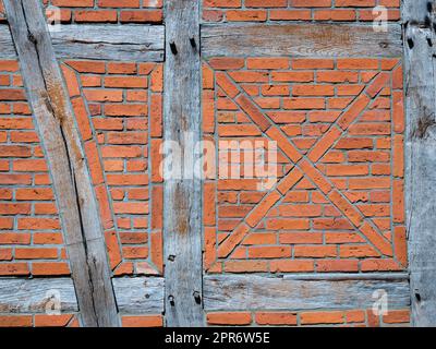 Old wall made of brown half-timbered, bricked with bricks in different shades Stock Photo