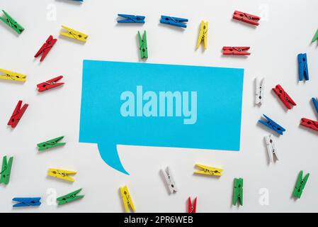 Colorful Pegs Placed Around Speech Bubble With Important Information. Wooden Clips Arranged All Over Dialogue Ballon With Crutial Idea. Pins With Critical Data Inside. Stock Photo