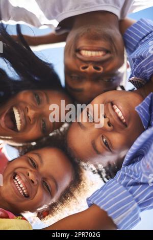 Family togetherness. Low view portrait of a happy african-american family spending the day at the beach together. Stock Photo