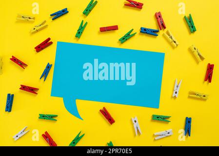 Colorful Pegs Placed Around Speech Bubble With Important Information. Wooden Clips Arranged All Over Dialogue Ballon With Crutial Idea. Pins With Critical Data Inside. Stock Photo