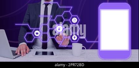 Businessman With A Laptop And A Tablet With Hand Pointing On A Pattern With Symbols Presenting Messages In A Futuristic Frame. Man Displaying New Data And Crucial Information. Stock Photo
