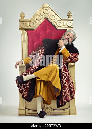 The thoughtful king. Studio shot of a richly garbed king sitting on a throne. Stock Photo