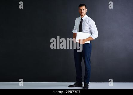 Make way for the next CEO. Studio portrait of a young businessman standing against a black background. Stock Photo