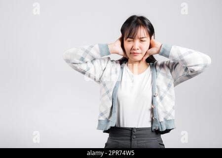 Woman bad mood pain her closed ears with hand palms and close eyes Stock Photo