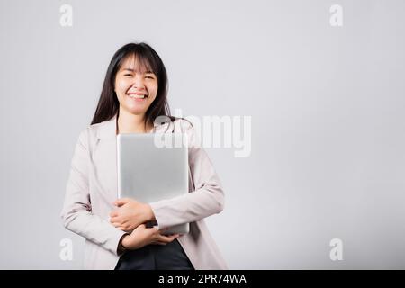 Front view woman smiling confident smiling holding closed laptop Stock Photo