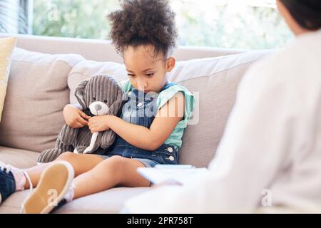 I cant talk about it. Shot of a psychiatrist talking to a little girl during a consultation. Stock Photo