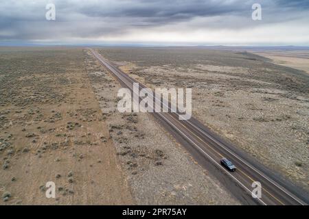 Car traveling through a dry desert Stock Photo