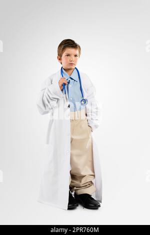 The doctor will see you now. Studio shot of an adorable little boy dressing up as a doctor. Stock Photo