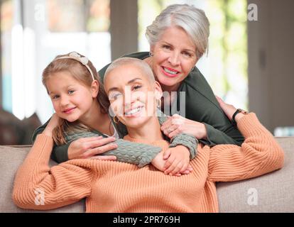 Keeping each other afloat. Portrait of a mature woman bonding with her daughter and granddaughter on the sofa at home. Stock Photo