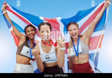 Diver British athletes celebrating their olympic gold medal wins, waving a Union Jack flag. Happy and proud champions of United Kingdom. Winning a medal for your country is an amazing achievement Stock Photo