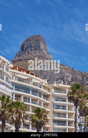 Copy space of Lions Head in Cape Town South Africa against a blue sky background from below. Panoramic of an iconic landmark and travel destination close to coastal apartment buildings and properties Stock Photo