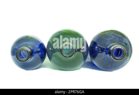 Three colorful glass bottles isolated on a white background. Wine bottle placed horizontally for a top view for its studio shot in a white isolation background having a drop shadow. Stock Photo