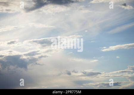 Blue sky with clouds and copy space during the day. Scenic view of dark, heavy storm rainclouds gathering in the distance. Atmosphere, global warming and climate change with stratus clouds and heaven Stock Photo