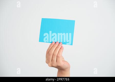 Businesswoman Holding Note With Important Message With One Hand. Woman Presenting Crutial Information On Piece Of Paper. Executive Showing Critical Announcement. Stock Photo