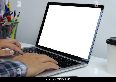 Hand man using keyboard computer laptop mock up blank white screen monitor technology online internet digital advertising business concept. Stock Photo