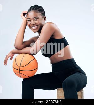 Ive been balling all day. Studio shot of a sporty young woman posing with a basketball against a studio background. Stock Photo
