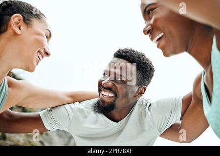 Making the most of this beautiful day. Shot of a group of friends huddled up before a workout. Stock Photo