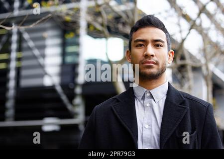 Off to work I go. Cropped portrait of a handsome young businessman standing outside during his morning commute into work. Stock Photo