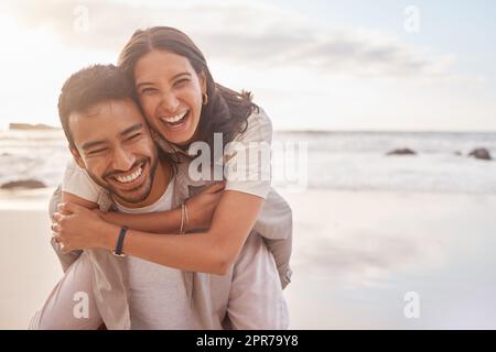 He makes every day exciting. a couple enjoying a day at the beach. Stock Photo