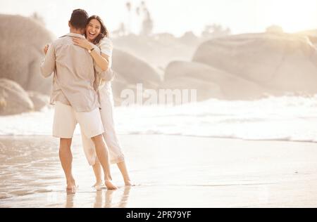 We dont need music to dance. a young couple dancing on the beach. Stock Photo