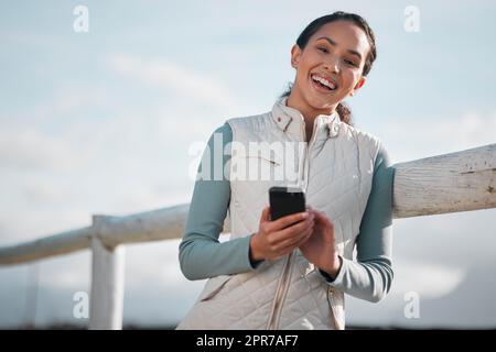 I still get perfect signal out here. an attractive young woman standing alone on her farm and using her cellphone. Stock Photo