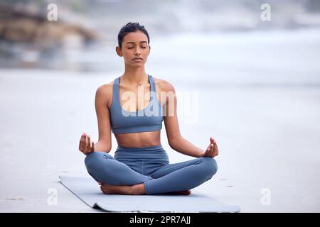 Finder inner peace. Full length shot of an attractive young woman  meditating while practicing yoga on the beach Stock Photo - Alamy