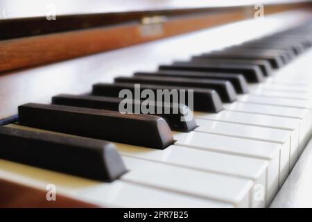 Closeup of classic wooden piano keys on display at a musical art gallery. A vintage keyboard on used to compose classical music or songs. Detail of an old and antique instrument Stock Photo
