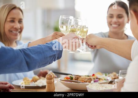 Heres to our family. a family toasting with wine while having lunch together at home. Stock Photo