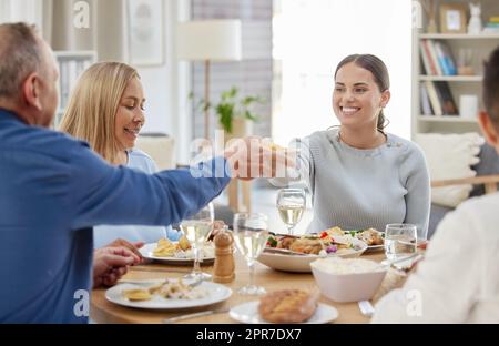 Could you pass the potatoes. a family having lunch together at home. Stock Photo