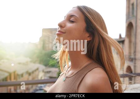 Profile of woman breathe relaxed with closed eyes on sunset. Beauty sunshine girl side portrait. Positive emotion life success mind peace concept. Stock Photo