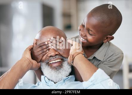 A happy family is but an earlier heaven. Shot of a boy and his grandpa bonding at home. Stock Photo