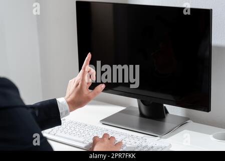 Businesswoman Typing Recent Updates On Lap Top Keyboard On Desk And Pointing Important Ideas With One Finger. Woman In Office Writing Late Messages On Computer. Stock Photo