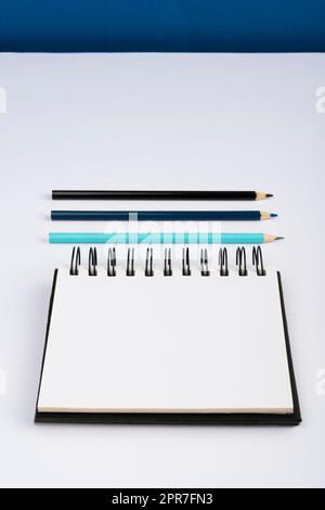 Important Message Written On Notebook Next To Pencils. Crutial Information Presented On Notepad Above Pens On Office Desk. Current Announcements Shown. Stock Photo