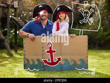 Happiness is having a large, loving, caring family. a father and daughter dressed up like pirates outside in the yard. Stock Photo