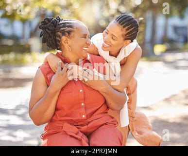 Happy mature woman and her adult daughter spending quality time together outside in the park during summer. Beautiful woman and her mother bonding outdoors. A senior lady and her adult child smiling Stock Photo