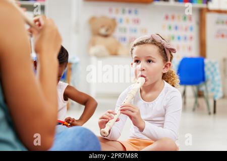 Music and children simply go together. a woman teaching her students about musical instruments in class. Stock Photo