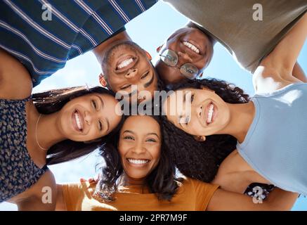 The only way to have a friend is to be one. Low angle shot of a group of young friends standing together with their heads in a huddle. Stock Photo